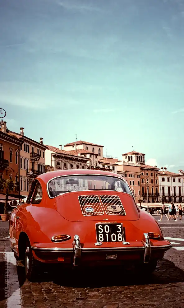 A photo of a red car with old buildings in the background, captured in Verona, Italy. The image has a CSS filter with 150% contrast, making it sharper and more vivid than the original.